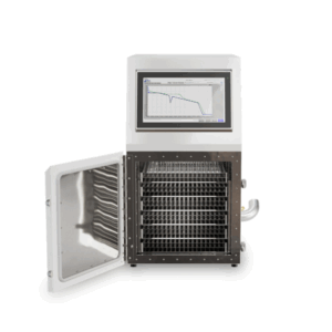 A laboratory freeze dryer with its front door open reveals multiple metal shelves inside. The device, similar to IntelliRate i67C Controlled Rate Freezers, has a digital display screen on top with a graph visible.